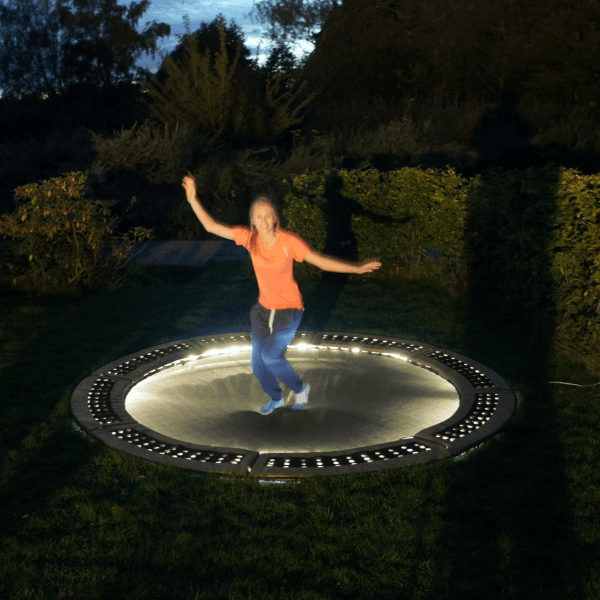 Child jumping on lit up trampoline